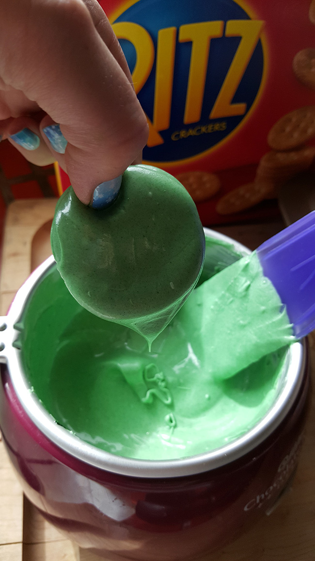 Dipping Ritz crackers in green chocolate