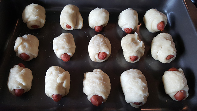 mini pretzel pigs in a blanket on cookie sheet