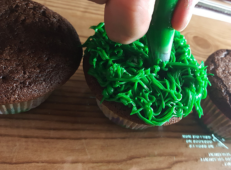 Adding grass frosting on cupcakes