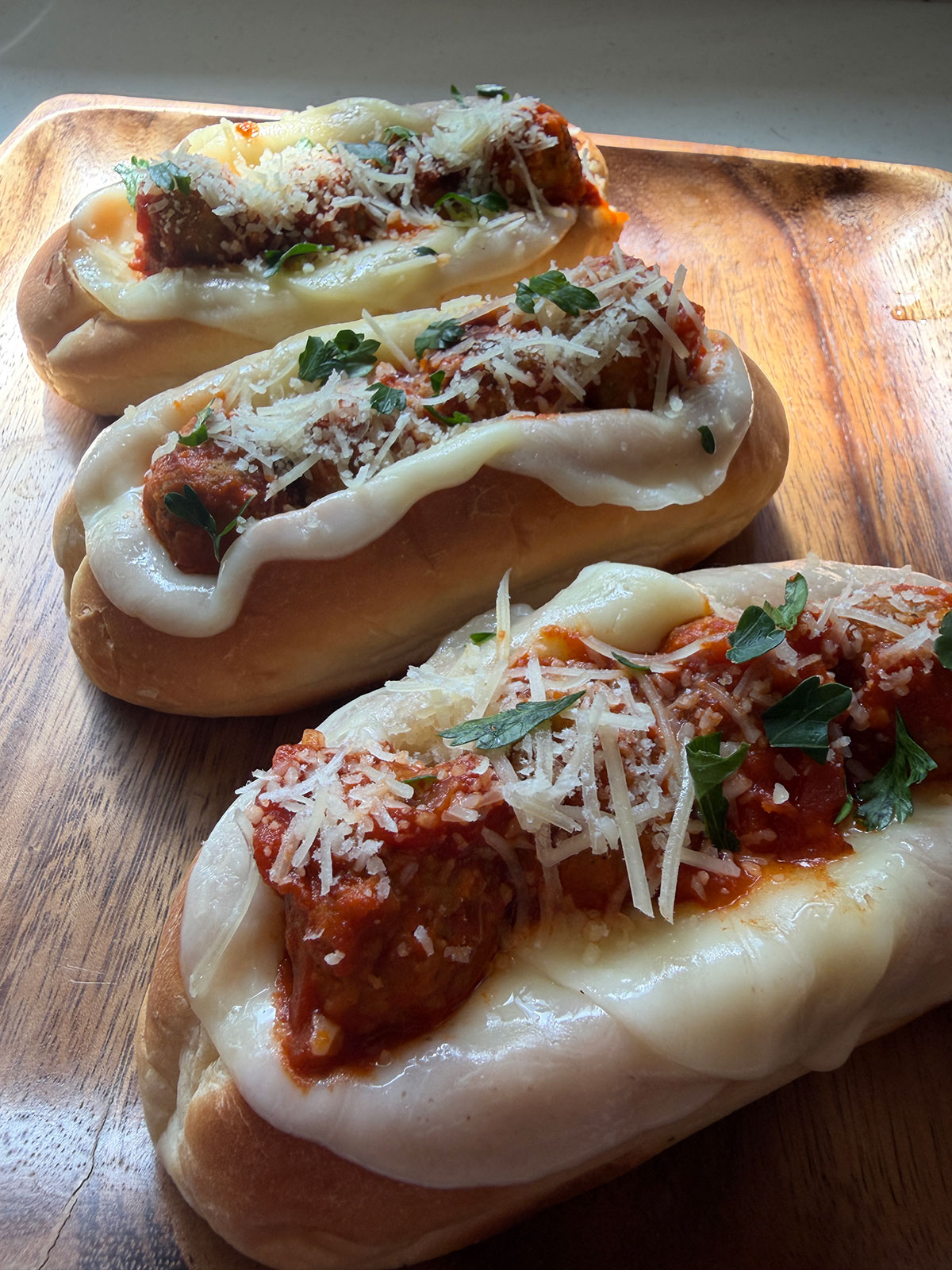 Easy garlic meatball boats with Rosina meatballs, marinara sauce, melted provolone, and parmesan cheese on toasted rolls