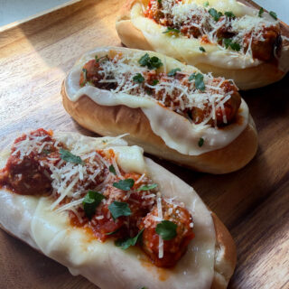 Garlic meatball boats made with Rosina Italian meatballs, marinara sauce, melted provolone cheese, and parmesan on toasted rolls