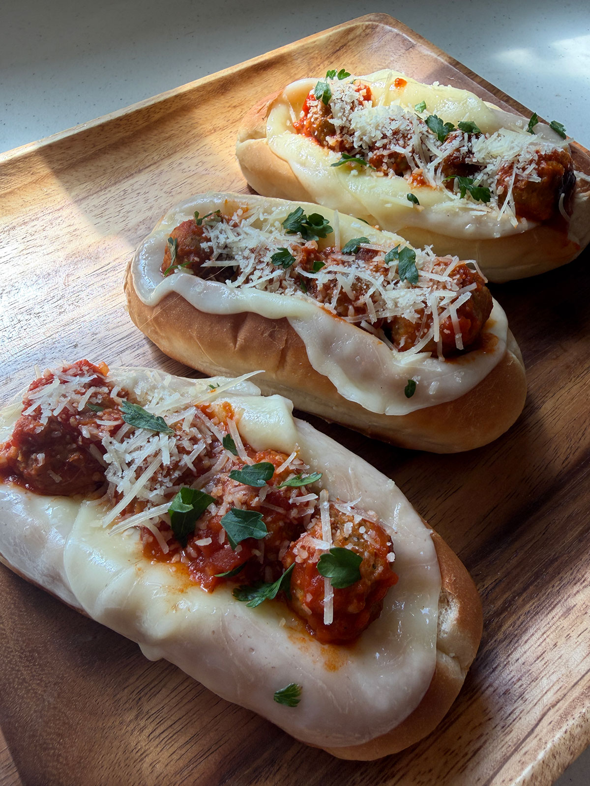 Garlic meatball boats made with Rosina Italian meatballs, marinara sauce, melted provolone cheese, and parmesan on toasted rolls